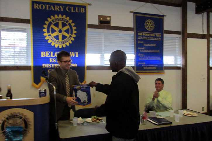 Louis Tenior Guerrier receiving Beloit Rotary Flag at Beloit Rotary Meeting